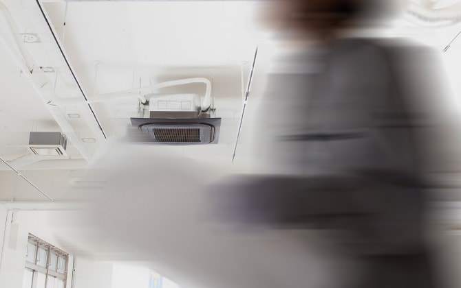 白い壁と天井の建物の中でブレた人物が写っている