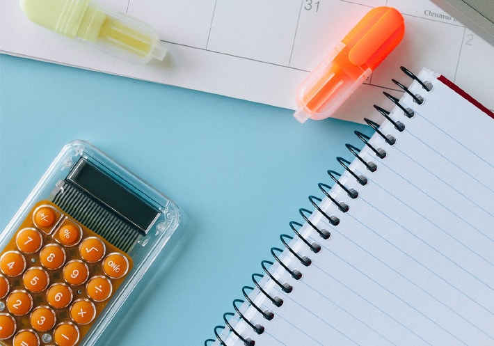 机に置かれているノートと電卓