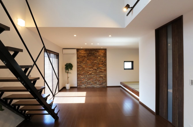 濃い茶色のフロアに階段と和室がある様子