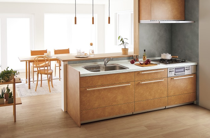 薄茶色が基調のキッチンと、白い壁で明るいダイニング